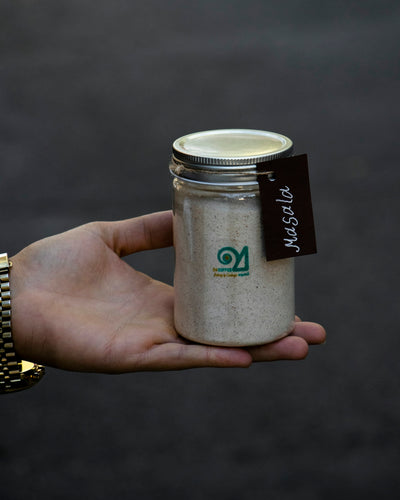 a hand holding a small container