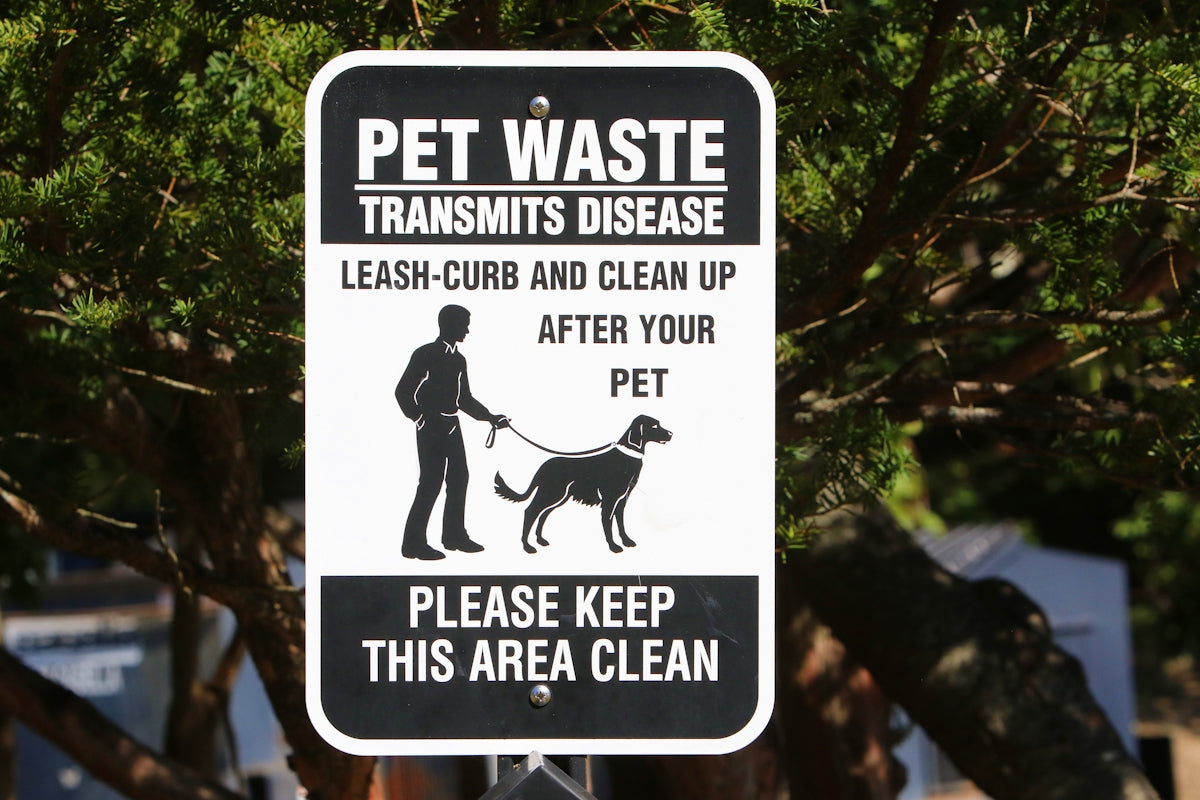 a black and white sign with a man and a dog on it